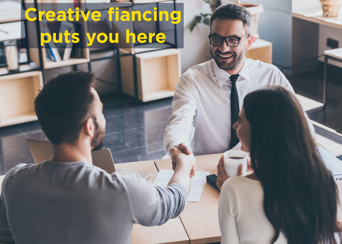 A happy real estate agent shakes hands with a man who just bought a home using creative fianncing.